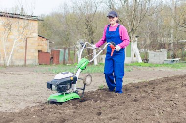 Genç kız bir bahar bahçesinde bir Kültüvatör ile çalışma.