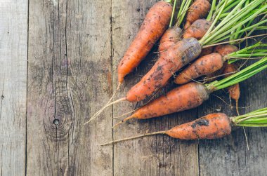 Taze kirli havuç eski bir ahşap masanın üzerinde yatan.