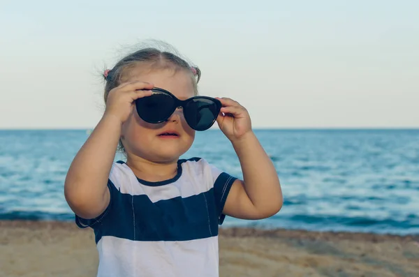 Güneş gözlüğü denizin kenarında küçük bir kız portresi — Stok fotoğraf