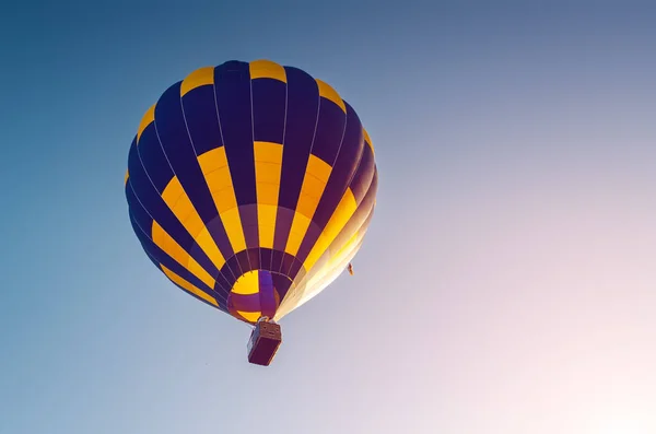 Balão de ar quente colorido voando no céu azul — Fotografia de Stock