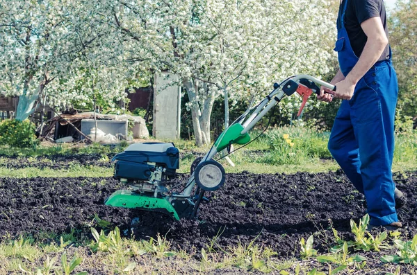 Bahar bahçede tiller makine ile çalışan adam — Stok fotoğraf