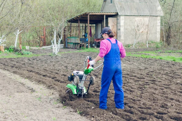 Junges Mädchen bei der Arbeit in einem Frühlingsgarten mit einem Kultivierer — Stockfoto