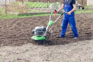 Bahar bahçede tiller makine ile çalışan adam