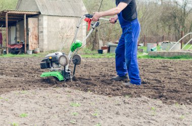 Bahar bahçede tiller makine ile çalışan adam