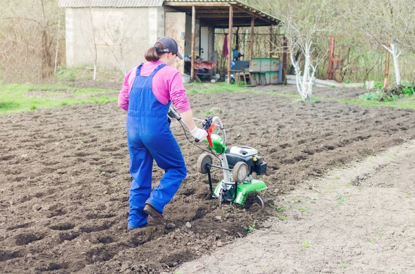 Junges Mädchen bei der Arbeit in einem Frühlingsgarten mit einem Kultivierer — Stockfoto