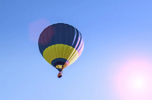 Kolorowy balon na gorące powietrze lecący na błękitnym niebie — Zdjęcie stockowe