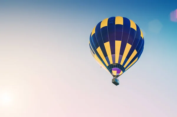 Πολύχρωμο αερόστατο θερμού αέρα που φέρουν στον μπλε ουρανό — Φωτογραφία Αρχείου