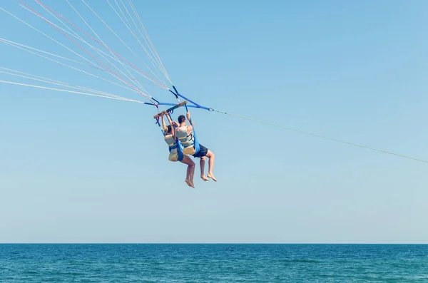 Fallschirmspringen ist ein Extremsport, Menschen fliegen mit dem Fallschirm gegen den blauen Himmel — Stockfoto