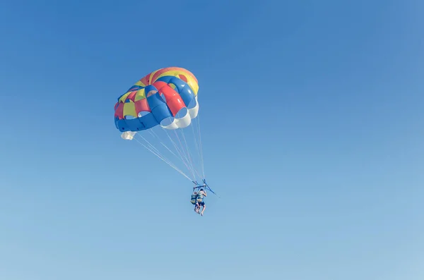 Parasailing es un deporte extremo, la gente vuela en paracaídas contra el cielo azul — Foto de Stock