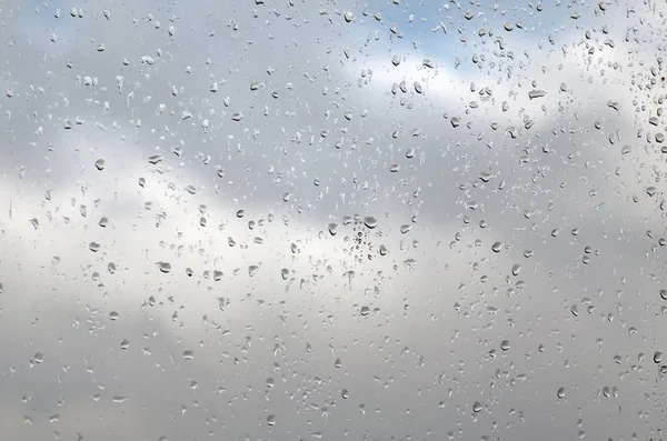 Gocce di pioggia su un pannello della finestra in un giorno di pioggia, sfondo texture — Foto Stock