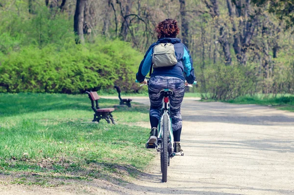 Girl riding a bike in a city park — Stock Photo, Image
