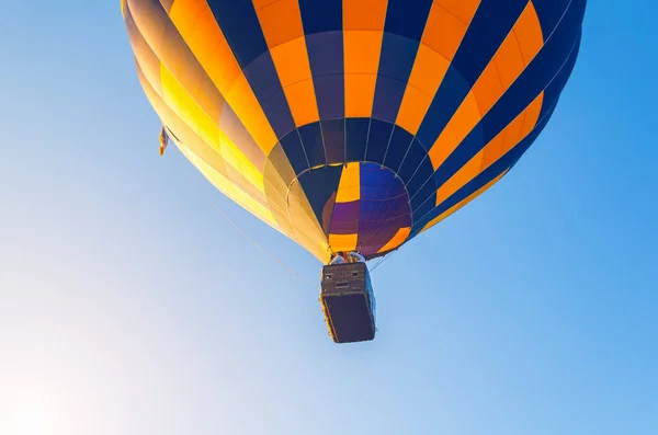 Barevný horkovzdušný balón létající na modré obloze — Stock fotografie