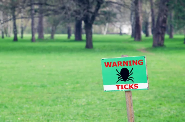 The sign on the lawn with the inscription: warning ticks