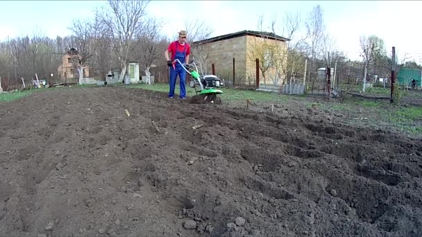 Der Mensch Bearbeitet Den Boden Garten Mit Einer Bodenfräse Und — Stockvideo