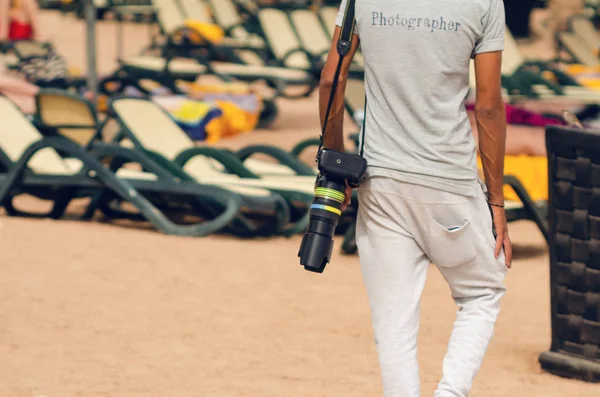 Un homme avec une caméra marchant sur la plage de la mer — Photo