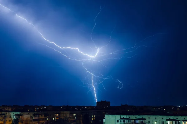 Gece şehri üzerinde şimşek ve gök gürültülü fırtına