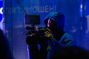 Belaya Tserkov, Ukrayna, 08 Şubat 2019: Bir kentsel olayı filme alan video kameralı bir adamın silueti