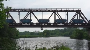 Yük treni nehir üzerindeki bir demiryolu köprüsüne biner.