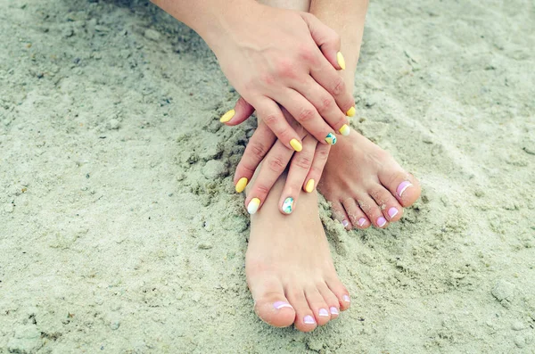 Weibliche Hände Mit Maniküre Und Beine Mit Französischer Pediküre Sand — Stockfoto