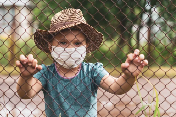 Criança Máscara Médica Atrás Uma Cerca Rua Pandemia Coronavírus Covid — Fotografia de Stock