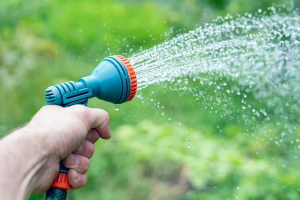 Trädgårdsmästarens Hand Håller Slang Med Spruta Och Vattnar Växterna Trädgården — Stockfoto