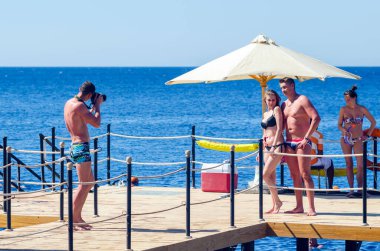 Sharm El Sheikh, Mısır 12 Mayıs 2019: Rıhtımdaki gençlerin fotoğraflarını çeken fotoğrafçı.