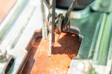 Bir marangoz elektrikli bir yapbozla tahtayı keser..