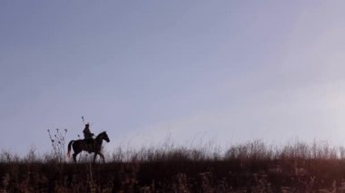 Gün batımının güzel arka planında ata binen