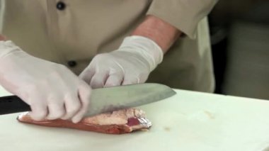 Şef çiğ ördek göğsü yapıyor.