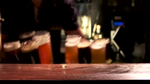 Бармен подает бокалы разливного пива бармена положить много различных сортов пива на стол — стоковое видео