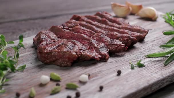 Bife de carne em uma tábua de madeira com especiarias — Vídeo de Stock