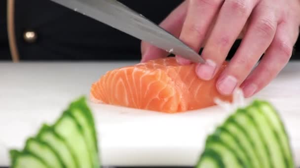 Шеф-повар режет лосося близко к нарезанной сырой рыбе — стоковое видео