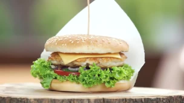 Куриный бургер на деревянной доске — стоковое видео