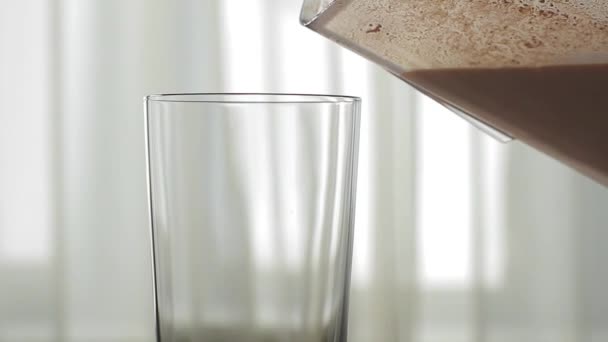 Coquetel de chocolate é derramado em um copo — Vídeo de Stock