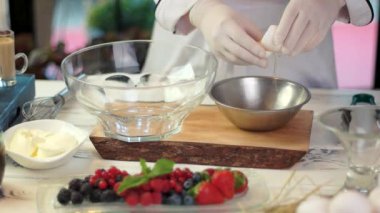 Tahta üzerinde yumurta akı kaselerini ayıran eller yemek pişirme ipuçları ve numaralar.