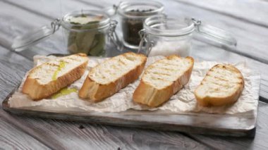 Ekmeğin üzerine sıvı dökülür ekmek dilimleri kağıt zeytinyağı üzerine ekmek dilimleri bruschetta için zeytin yağı
