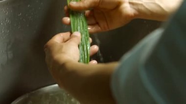 Erkek elleri yeşil soğan yıkar.