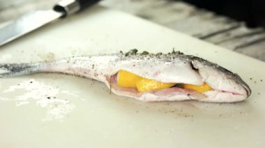 Çiğ doldurulmuş dorado balığı, yemek hazırlama baharatları ve yağ.