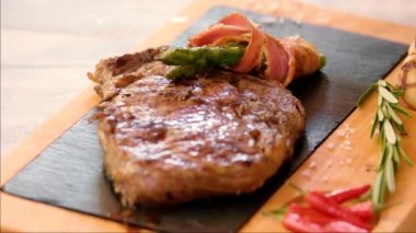 Güvertede pirzola var. Yiyeceğe tuz ekliyor.