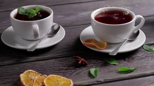 Tasses de thé avec différentes épices et menthe thé noir — Video