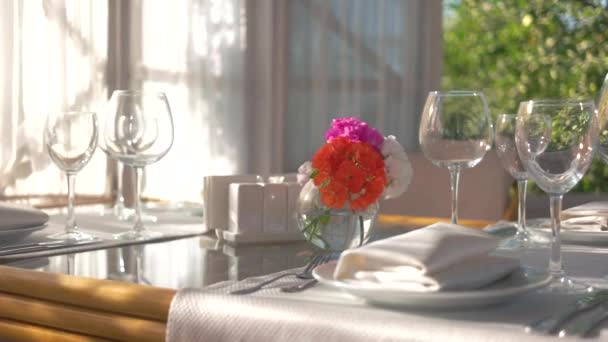 Eettafel vaas met bloemen lege glazen op wit tafelkleed — Stockvideo