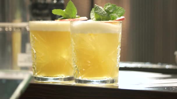 Copos de coquetéis amarelos tomando bebida do balcão do bar — Vídeo de Stock