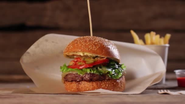 Sopalı hamburger ve ahşap arka planda kolayla abur cubur. — Stok video