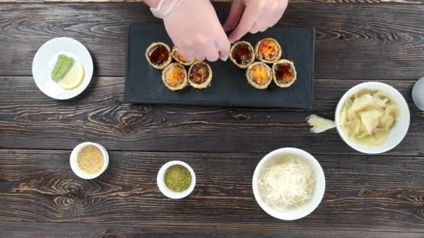 Ręce przygotowanie sushi imbir unagi maki rolki na talerzu — Wideo stockowe