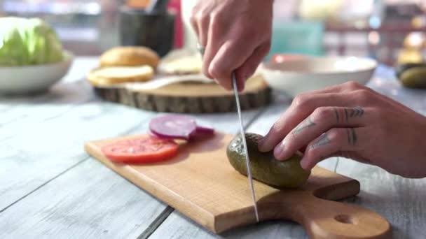 Manos masculinas cortar verduras en rodajas de pepinillo en madera tablero — Vídeo de stock