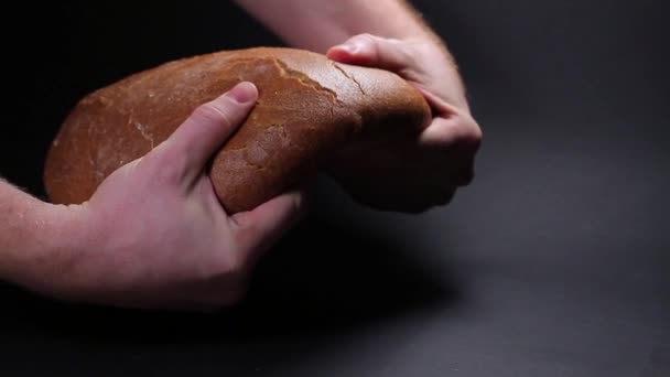 Чоловіча рука розбиває коричневий хліб — стокове відео