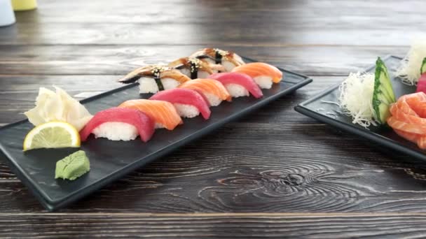 Nigiri ve sashimi ahşap masa. Lezzetli yemekler. — Stok video