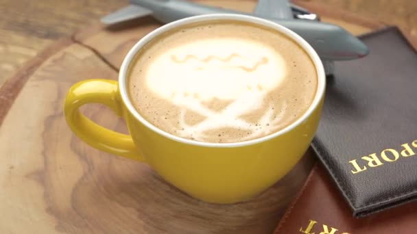 Paszporty kawa i zabawka samolot filiżanka latte na desce drewnianej — Wideo stockowe