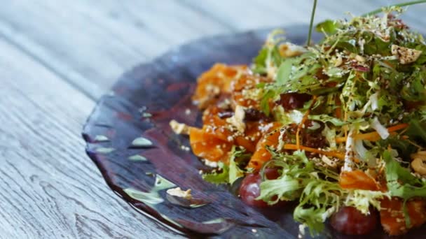 Салат с рыбой и зеленым салатом на деревянном фоне — стоковое видео
