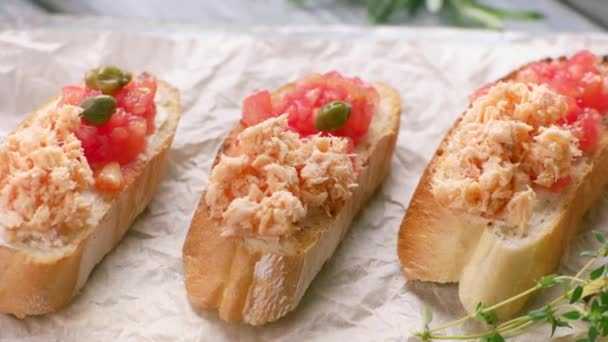 Pinzas poner alcaparras en sándwiches rebanadas de baguette con bruschetta de pescado con salmón — Vídeo de stock